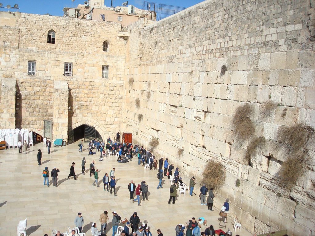 Die weiße Klagemauer in Jerusalem von seitlich, oben fotografiert, zahlreiche Menschen stehen vor der Mauer