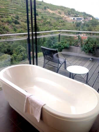 Freistehende Badewanne mit Ausblick auf die Weinberge im Steigenberger Krems