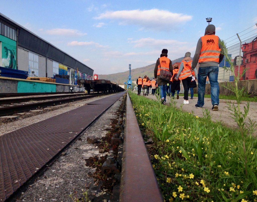 Entlang der Gleise geht es zum Boot. Da es ein Industriegelände ist, müssen Warnwesten getragen werden.